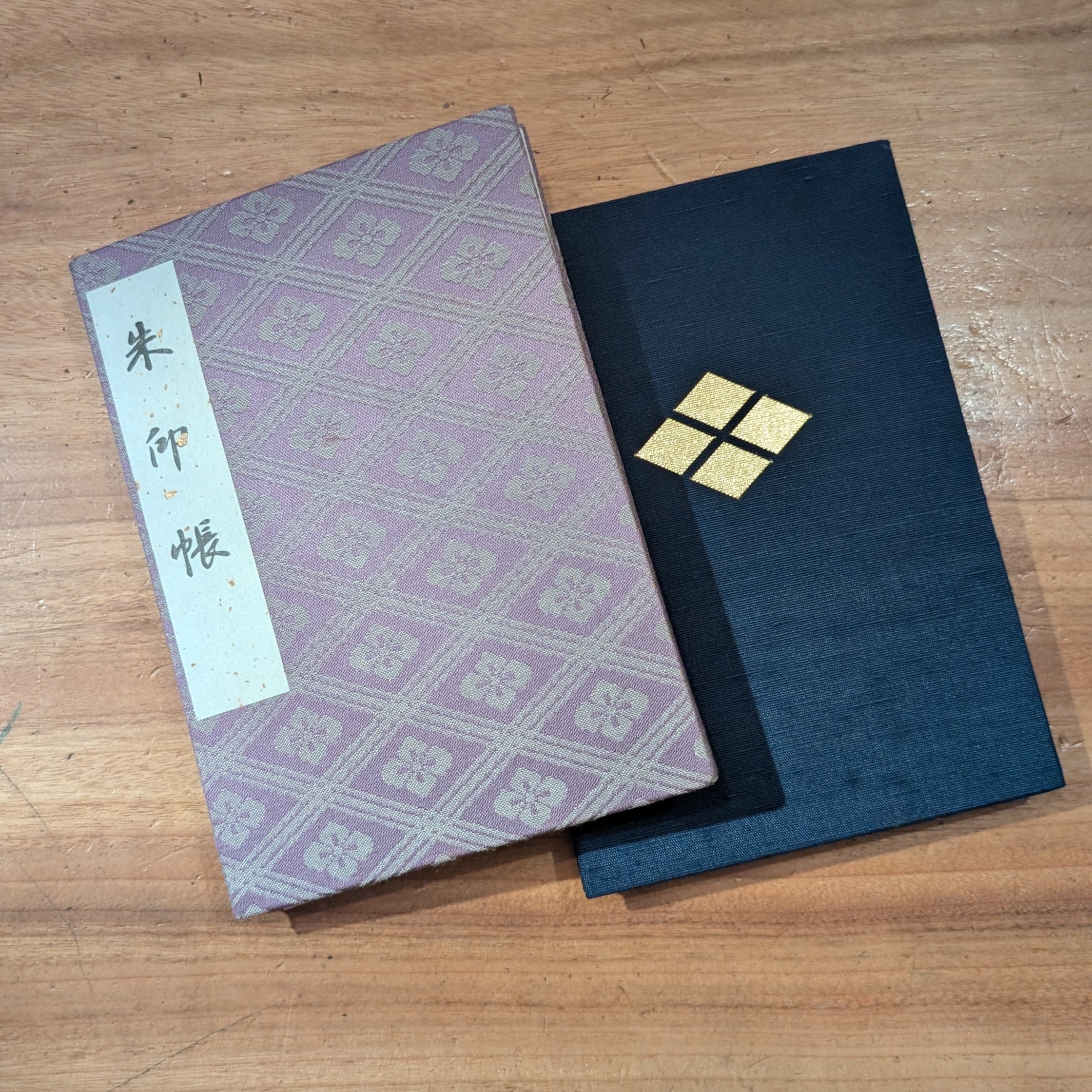 机に重ねて置いた、紫色と紺色の二冊の御朱印帳